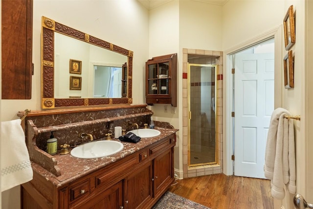 bathroom with wood-type flooring, an enclosed shower, and vanity