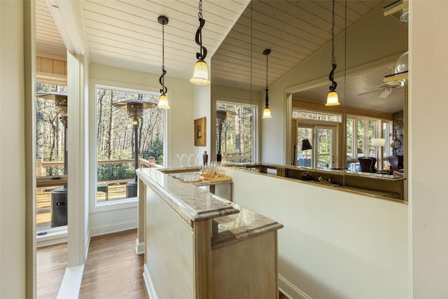 bar featuring light stone countertops, hardwood / wood-style floors, hanging light fixtures, and wooden ceiling