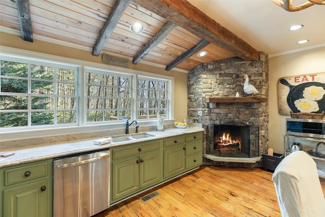 kitchen featuring sink, stainless steel dishwasher, a fireplace, and green cabinetry