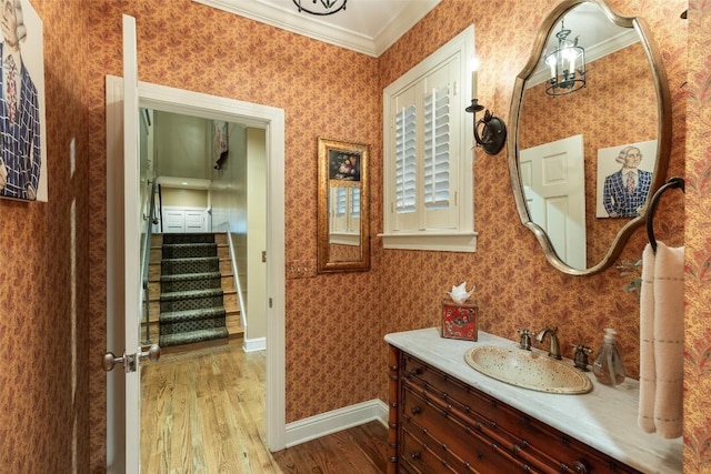 bathroom featuring ornamental molding, vanity, and hardwood / wood-style floors