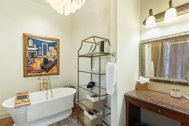 bathroom featuring a chandelier, crown molding, a bathing tub, and hardwood / wood-style floors