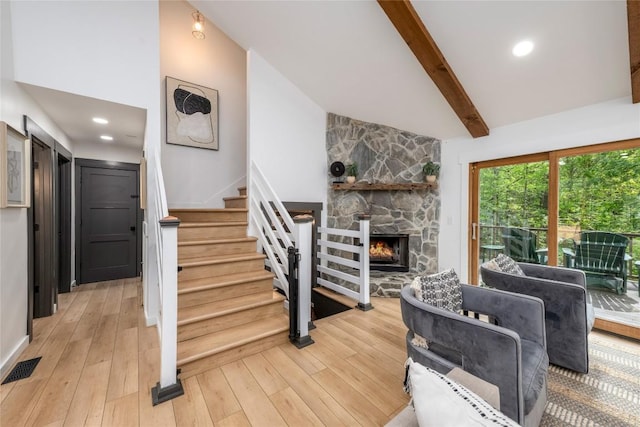 79 Azalea Ct, Sapphire, NC 28774 - living area featuring a stone fireplace, stairway, light wood-style flooring, beamed ceiling, and high vaulted ceiling
