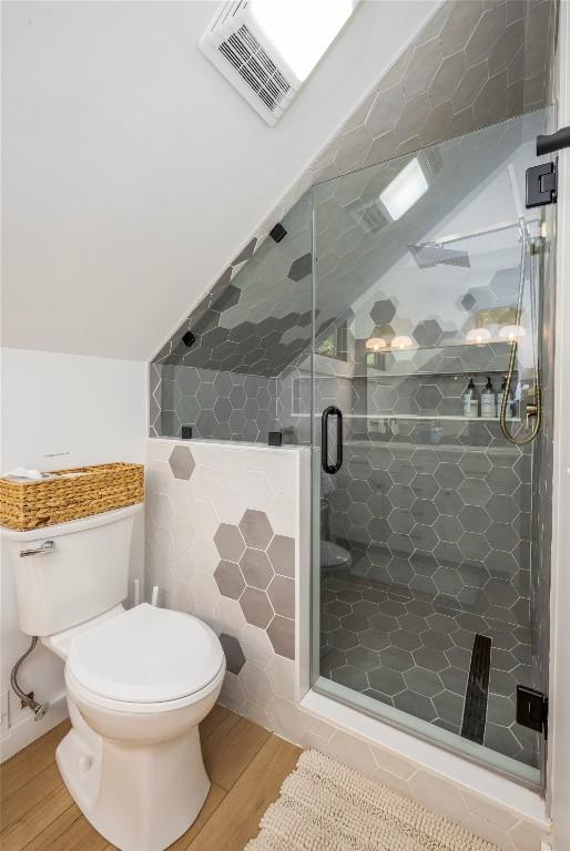 79 Azalea Ct, Sapphire, NC 28774 - full bathroom with wood finished floors, toilet, a shower stall, tile walls, and lofted ceiling