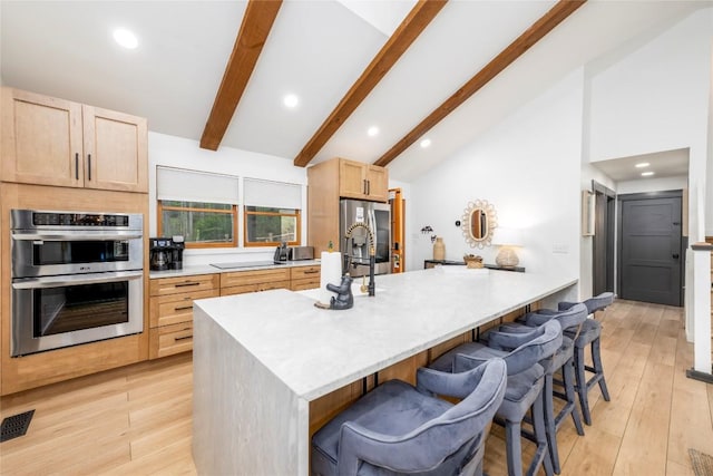 79 Azalea Ct, Sapphire, NC 28774 - kitchen featuring stainless steel appliances, light brown cabinetry, a kitchen bar, beam ceiling, and recessed lighting