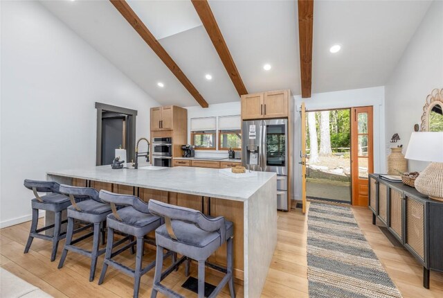 79 Azalea Ct, Sapphire, NC 28774 - kitchen with stainless steel appliances, a breakfast bar area, light wood-style flooring, a large island with sink, and recessed lighting