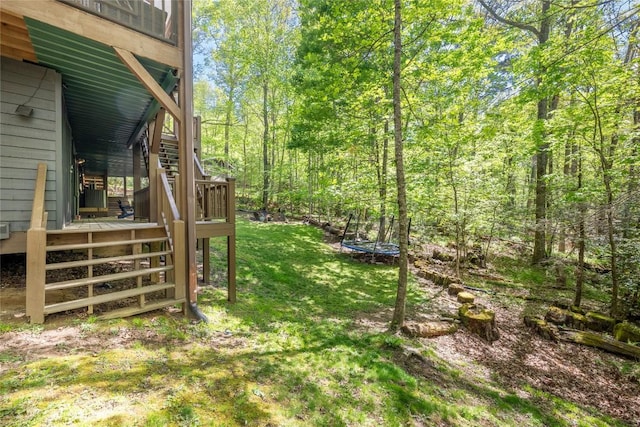 79 Azalea Ct, Sapphire, NC 28774 - view of green lawn featuring stairs, a trampoline, and a wooden deck