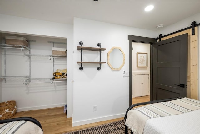79 Azalea Ct, Sapphire, NC 28774 - bedroom with a barn door, a closet, baseboards, and wood finished floors