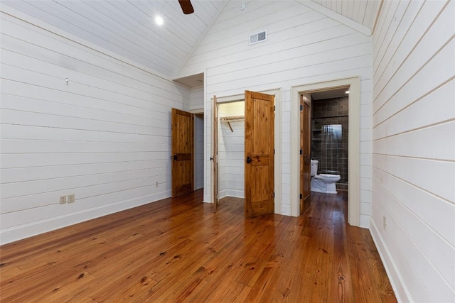 96 Mahalo Ln, Cullowhee, NC 28723 - unfurnished bedroom with a spacious closet, hardwood / wood-style floors, wooden walls, a closet, and high vaulted ceiling