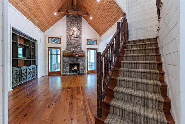96 Mahalo Ln, Cullowhee, NC 28723 - staircase with hardwood / wood-style flooring, wooden ceiling, a chandelier, high vaulted ceiling, and a stone fireplace