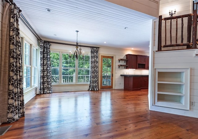 96 Mahalo Ln, Cullowhee, NC 28723 - unfurnished living room with a chandelier, wood finished floors, and wooden walls