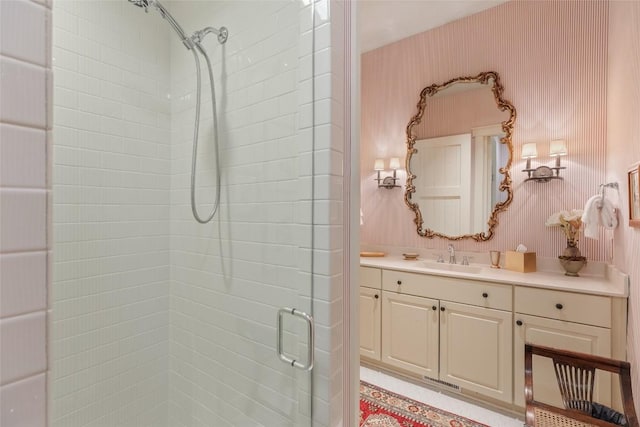 bathroom with vanity, wallpapered walls, and a stall shower