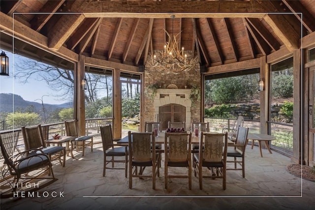 sunroom featuring an inviting chandelier, a mountain view, and a wealth of natural light