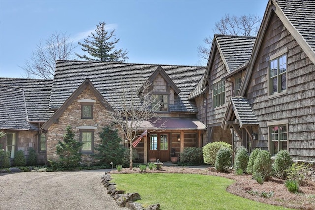 view of front of property featuring a front lawn and stone siding