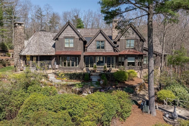 back of property with french doors and a chimney