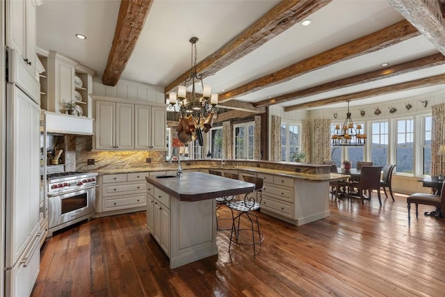 kitchen featuring dark wood-style flooring, a breakfast bar area, high quality appliances, a chandelier, and a sink