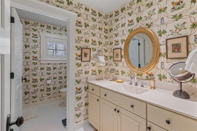 bathroom featuring vanity, toilet, and wallpapered walls