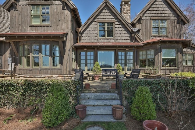 back of house featuring board and batten siding and a chimney