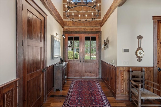 doorway to outside with french doors, wainscoting, wooden walls, and wood finished floors