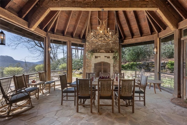 sunroom / solarium with a mountain view and a chandelier