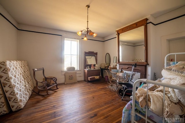 bedroom featuring dark wood-type flooring and an inviting chandelier