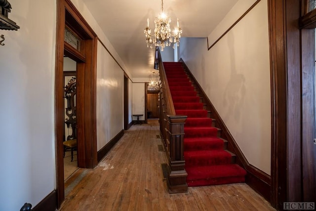 corridor with a chandelier and hardwood / wood-style floors