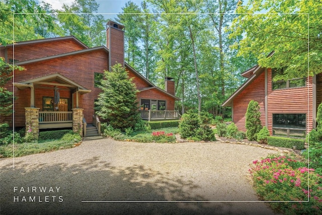 61 Carnoustie Dr, Sapphire, NC 28774 - view of front facade featuring covered porch, a chimney, and gravel driveway