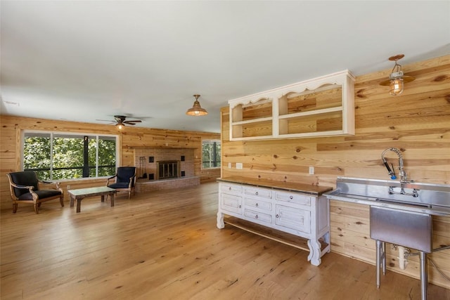 228 Mountain Laurel Dr, Franklin, NC 28734 - living area with wood walls, a ceiling fan, healthy amount of natural light, and light wood-style flooring