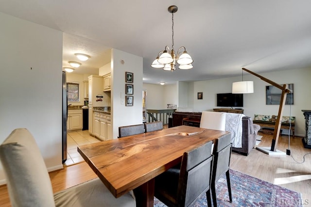 dining area with a notable chandelier and light hardwood / wood-style flooring