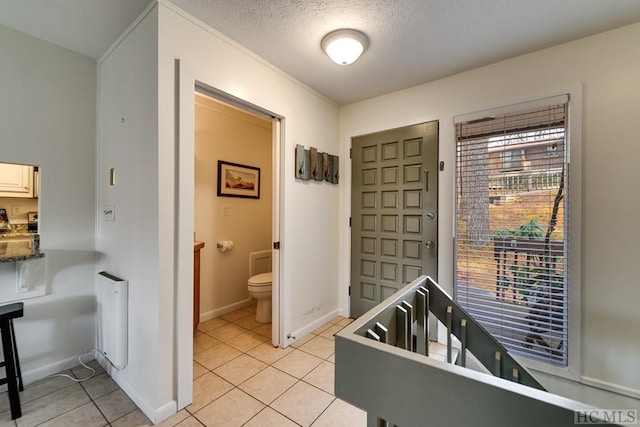 bathroom with radiator, tile patterned floors, a textured ceiling, and toilet