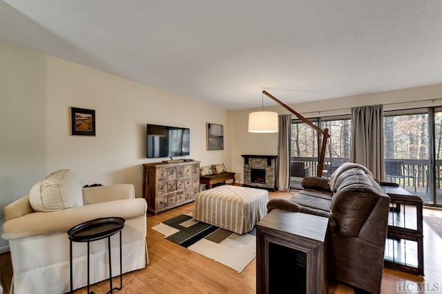 living room featuring hardwood / wood-style floors and a stone fireplace