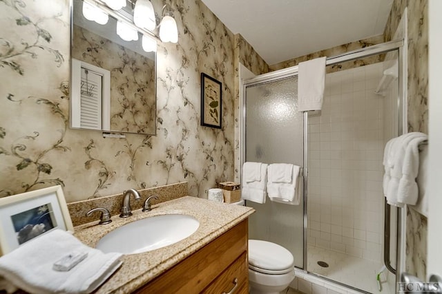 bathroom with vanity, toilet, and a shower with shower door