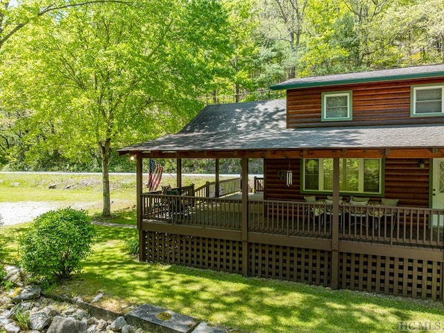 2177 Buck Creek Rd, Highlands, NC 28741 - rear view of house featuring a wooded view, a wooden deck, faux log siding, a lawn, and a shingled roof