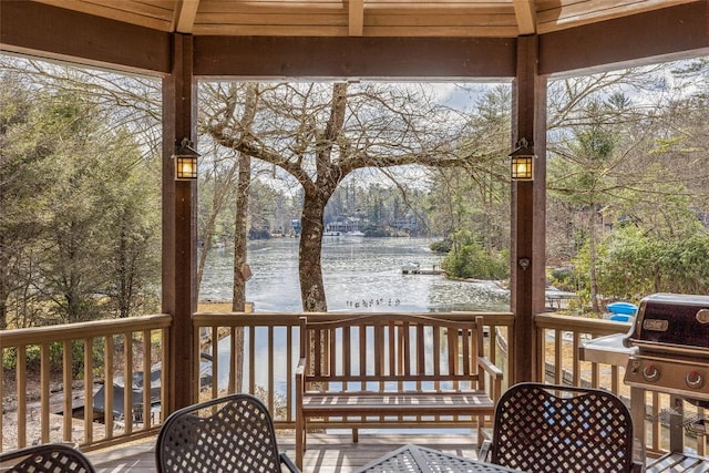 sunroom featuring a water view