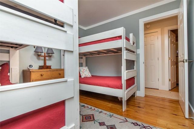 bedroom with wood-type flooring and ornamental molding