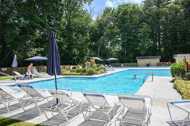 47 Red Bud Ct, Sapphire, NC 28774 - community pool with a patio area, view of scattered trees, and a storage unit