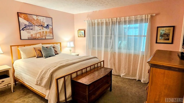 bedroom with dark colored carpet and a textured ceiling