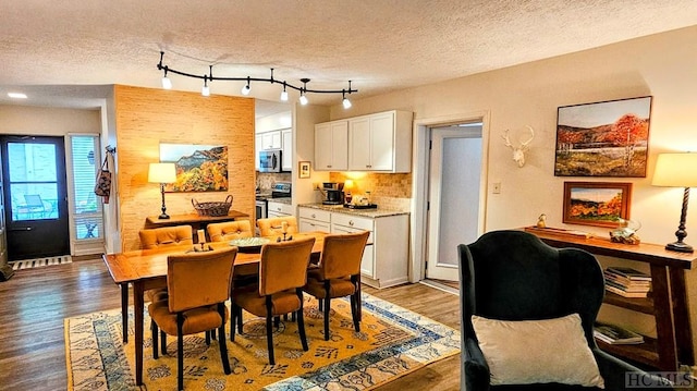 dining room with wood-type flooring and a textured ceiling