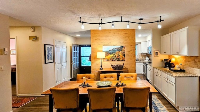 kitchen featuring dark wood-type flooring, tasteful backsplash, appliances with stainless steel finishes, light stone countertops, and white cabinets