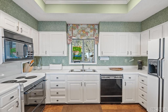 kitchen featuring white cabinetry, a tray ceiling, sink, and black appliances