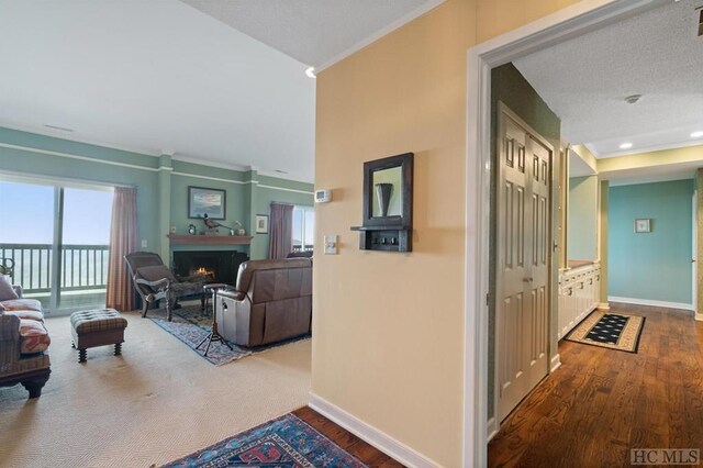 hall featuring crown molding, wood-type flooring, and a textured ceiling