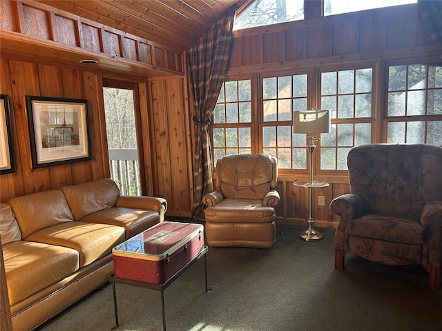 carpeted living room with lofted ceiling, wood ceiling, and wood walls