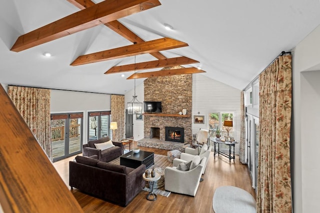 living area with a stone fireplace, beam ceiling, wood finished floors, and high vaulted ceiling