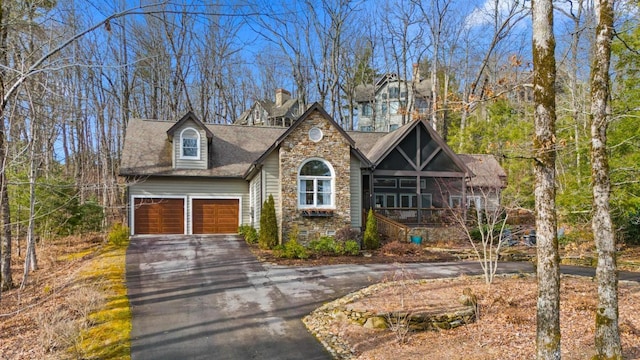 view of front of home with aphalt driveway, stone siding, an attached garage, and crawl space