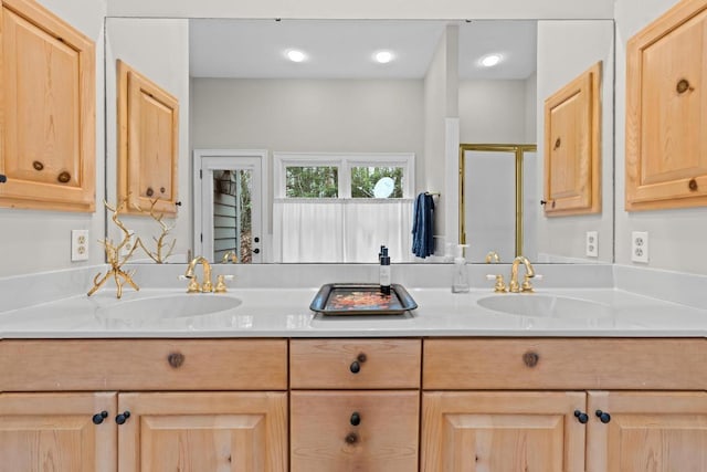 bathroom featuring a sink, a stall shower, and double vanity