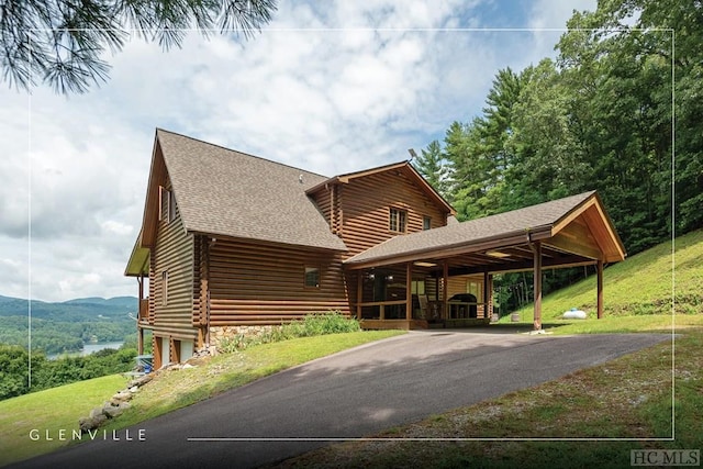 view of front of property with a mountain view, a front lawn, and a carport