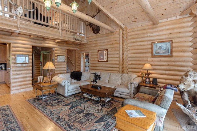 living room featuring rustic walls, wooden ceiling, light wood-type flooring, beam ceiling, and a high ceiling