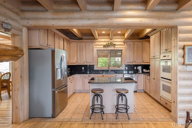 kitchen featuring sink, rustic walls, stainless steel appliances, a center island, and light brown cabinetry