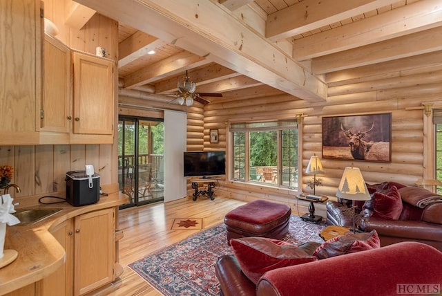 living room featuring light hardwood / wood-style flooring, sink, log walls, and plenty of natural light