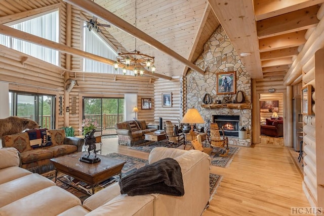 living room with light hardwood / wood-style floors, a fireplace, rustic walls, and high vaulted ceiling