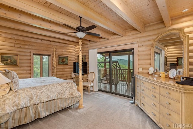 carpeted bedroom with multiple windows, access to outside, and rustic walls